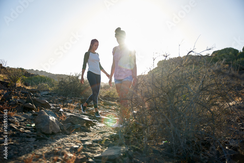 Young girls walking down rocky path photo