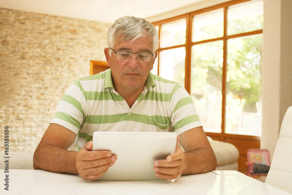 Older man using an electronic tablet. Older man using an electronic tablet.