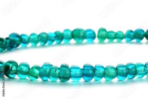 Ancient glass trade beads in necklace on white background