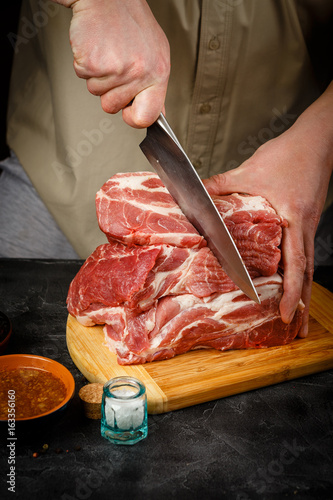 Close up of Male hands chopping knife pork