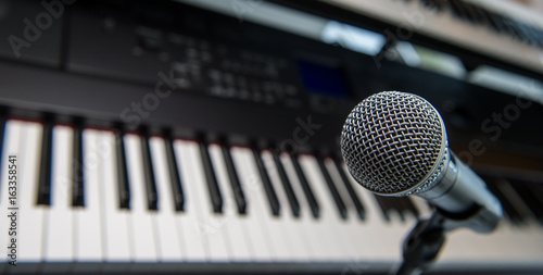 Studio room with synthesizer and microphone equipment.