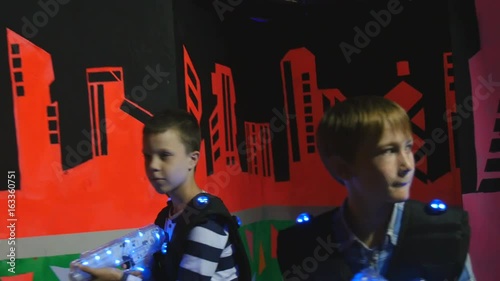 Children in the equipment for playing laser tag walk through the labyrinth