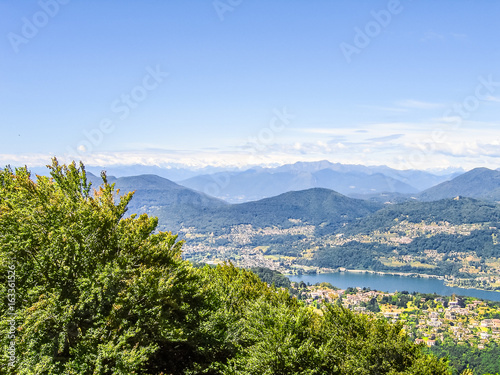 Aerial view of Lugano city with houses, lake and cityscape, and alpine Swiss mountains
