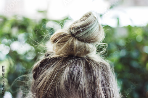 Topknot ponytail woman haircut on the green background 