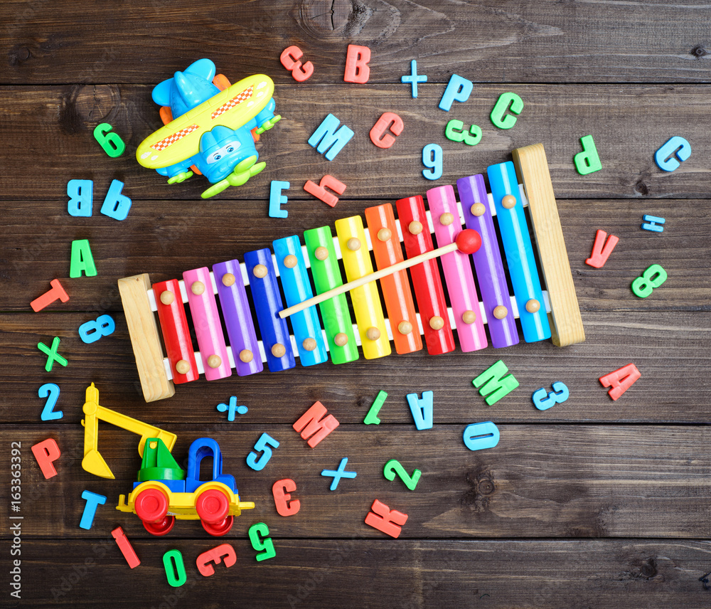 boys toys and colord letters on wooden table. top view. boys toys and colord letters on wooden table. top view.