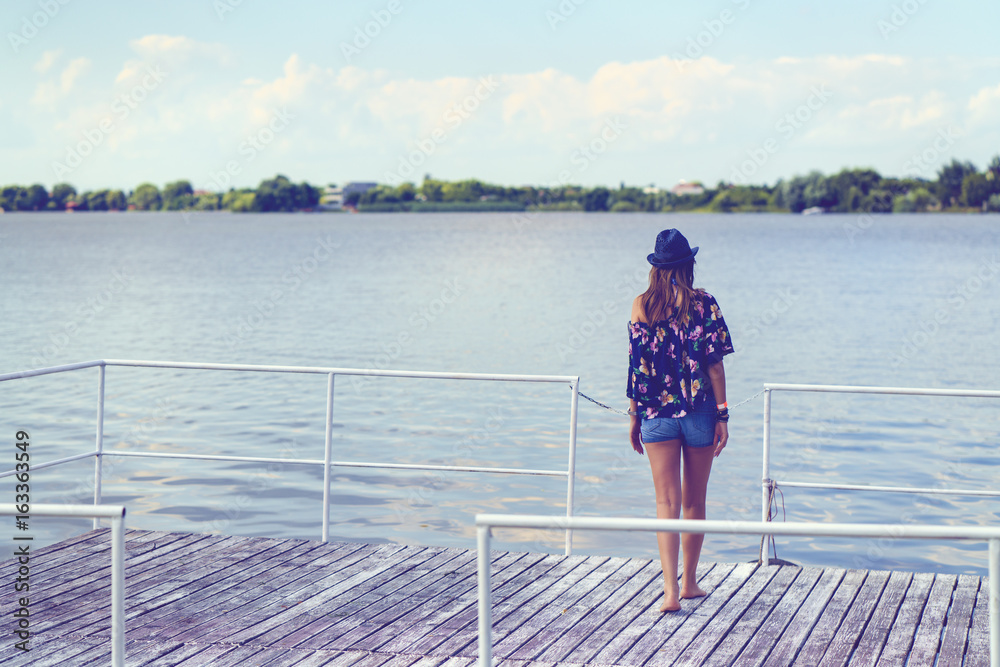 Woman sitting on a pontoon on the edge of a lake