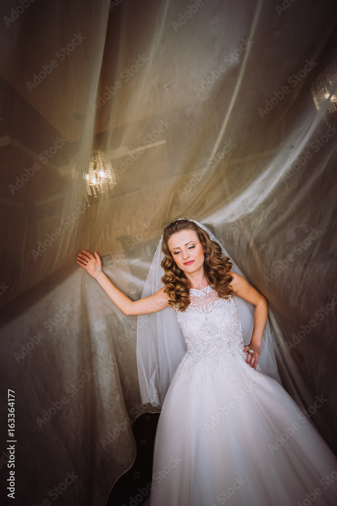 Portrait of beautiful bride model with perfect makeup and hair style in light room in a morning Portrait of beautiful bride model with perfect makeup and hair style in light room in a morning