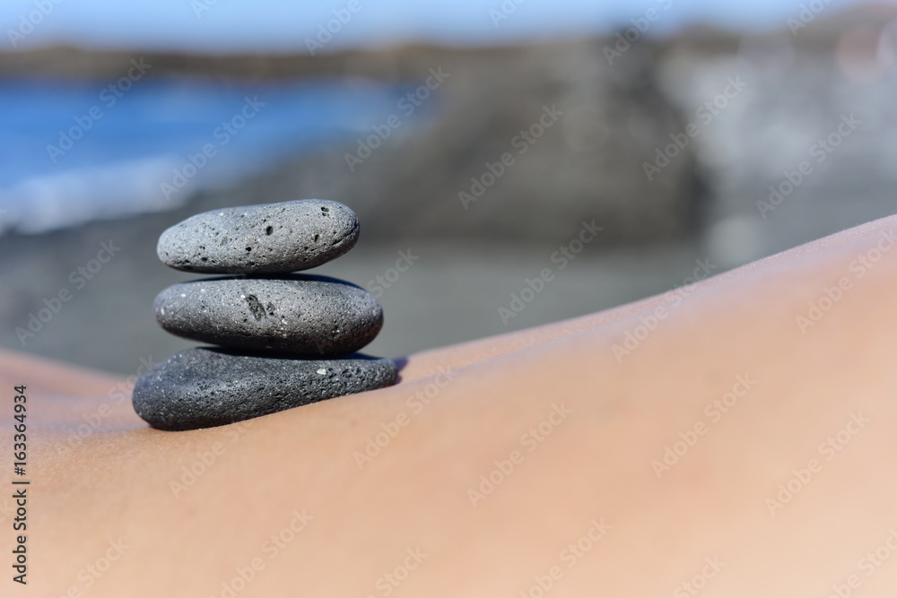 stones on the back of a man on the beach Stock Photo | Adobe Stock