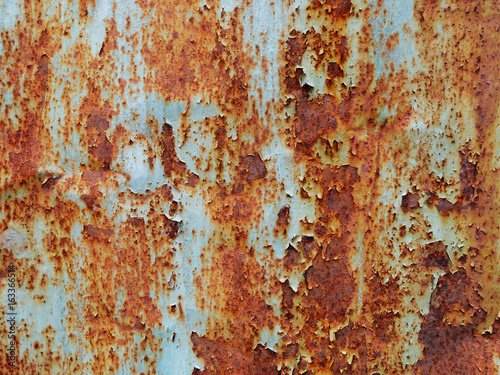 Rusty metallic surface with cracked blue paint