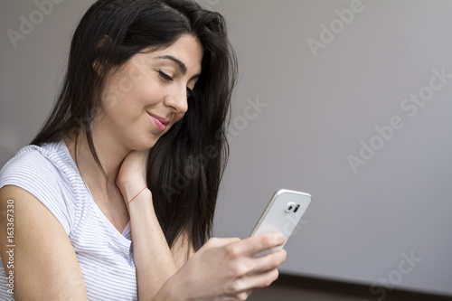 Portrait of beautiful  smiling woman using mobile phone