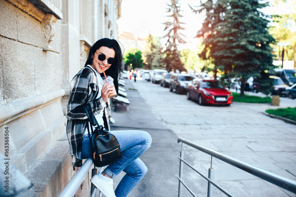 Pretty long hair brunette girl enjoy cold coffee on the street