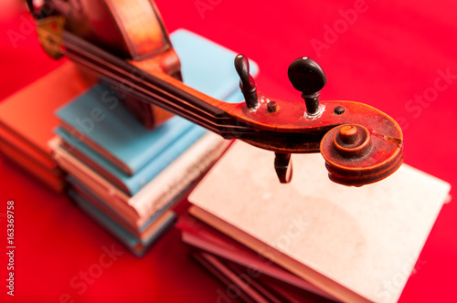 Music instrument old violin on a book and pile of books