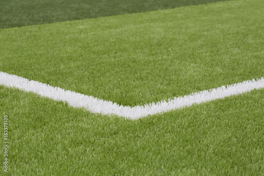 A closeup photo taken on a football field line paint marking.