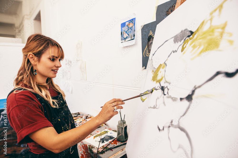Obraz premium Woman artist making a painting in her studio
