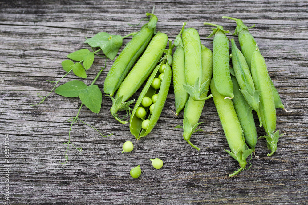 Pods of green peas on a old wooden surface close up, top view Pods of green peas on a old wooden surface close up, top view
