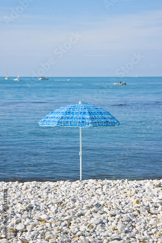 Colorful umbrella isolated on a beach of small stones