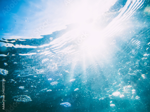 Underwater wave in tropical sea and sun rays. Water in ocean