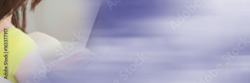 Fototapeta Naklejka Na Ścianę i Meble -  Back of woman typing on laptop with blurry purple transition