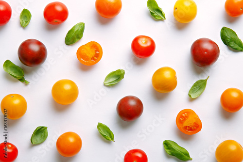 Fresh cherry tomato pattern. Various colorful tomatoes on a white background. Repetition concept. Top view