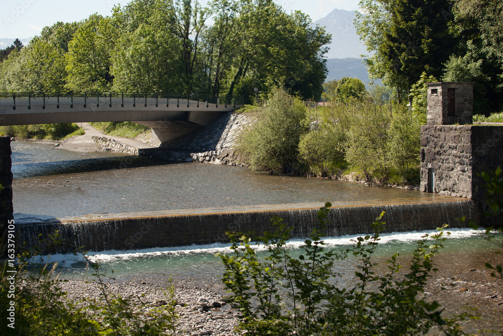 Fototapeta premium Brücke und Wehr über den Alpenfluss Frutz, Vorarlberg