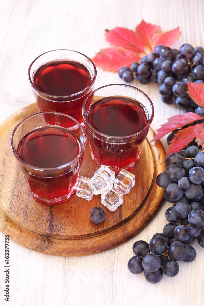 Three glasses of grape juice with ice and black grapes Three glasses of grape juice with ice and black grapes