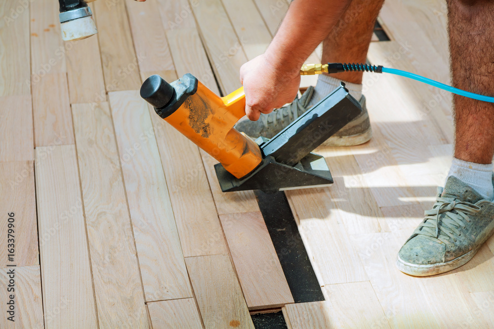 carpenter worker installing wood parquet board carpenter worker installing wood parquet board