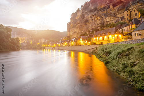 Beautiful view on Dordogne river and illuminated La Roque Gageac village during the rainy weather in France