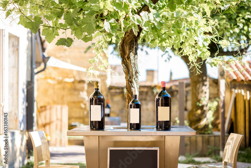 Murais de parede Wine bottles with blank label and board to copy paste outdoors on the tabel