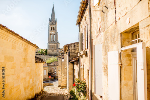 Fototapeta Naklejka Na Ścianę i Meble -  Street view in Saint Emilion village with church tower during the sunset in France