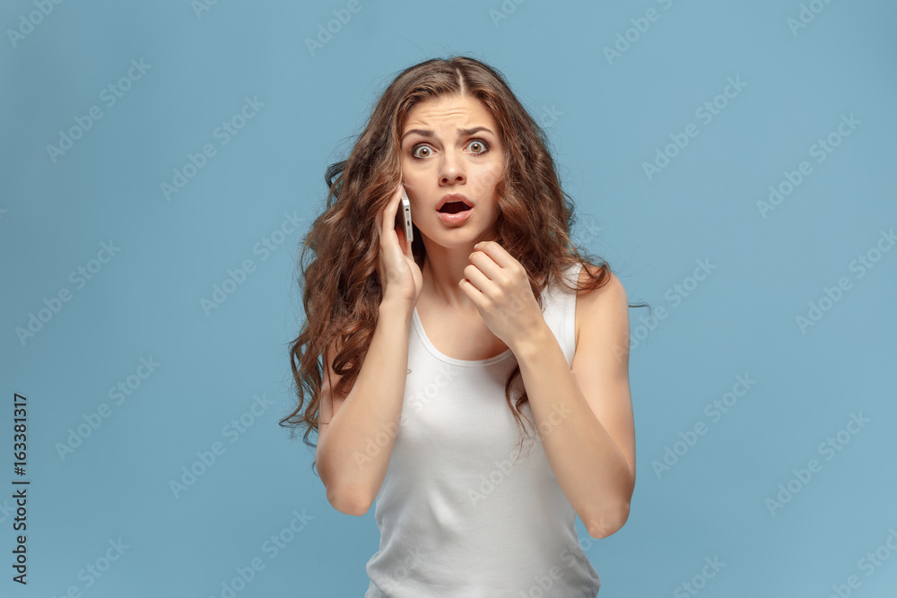 Fototapeta premium The portrait of disgusted woman with mobile phone
