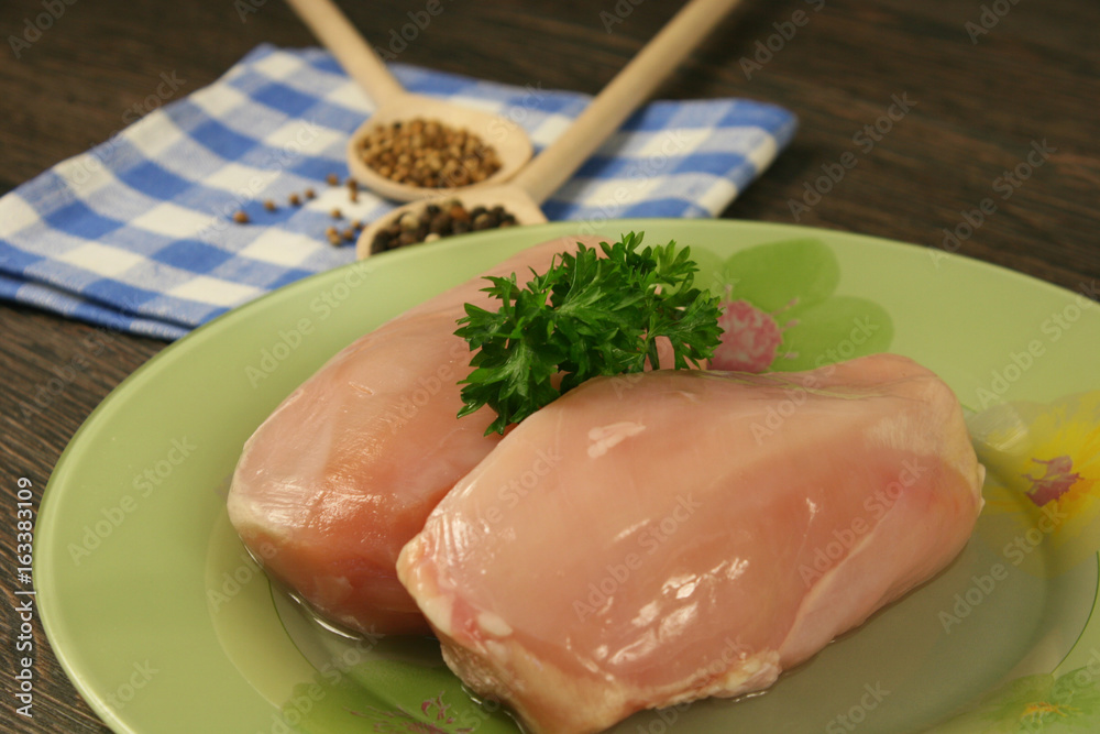 Raw chicken breast and spices close up. Selective focus Raw chicken breast and spices close up. Selective focus