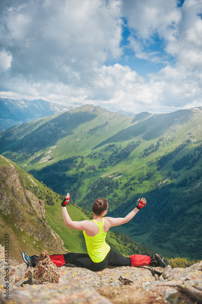 Fototapeta premium Woman doing exercise on the top of mountain