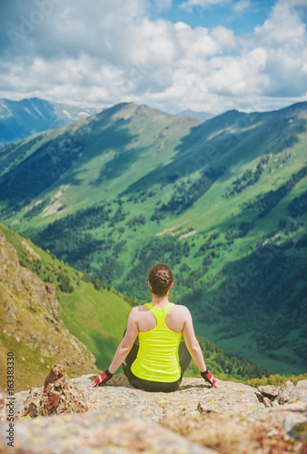 Woman doing relax exercise on the top of mountain