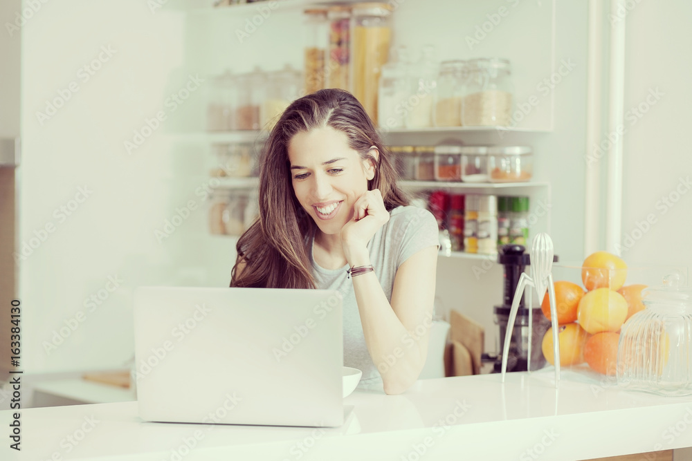 Young woman in kitchen looking for a healthy breakfast recipe Young woman in kitchen looking for a healthy breakfast recipe