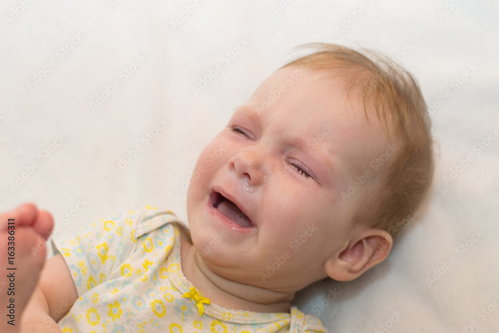 Baby crying on white isolated background. Symptoms of colds runny