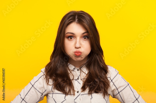 Woman making grimace on yellow