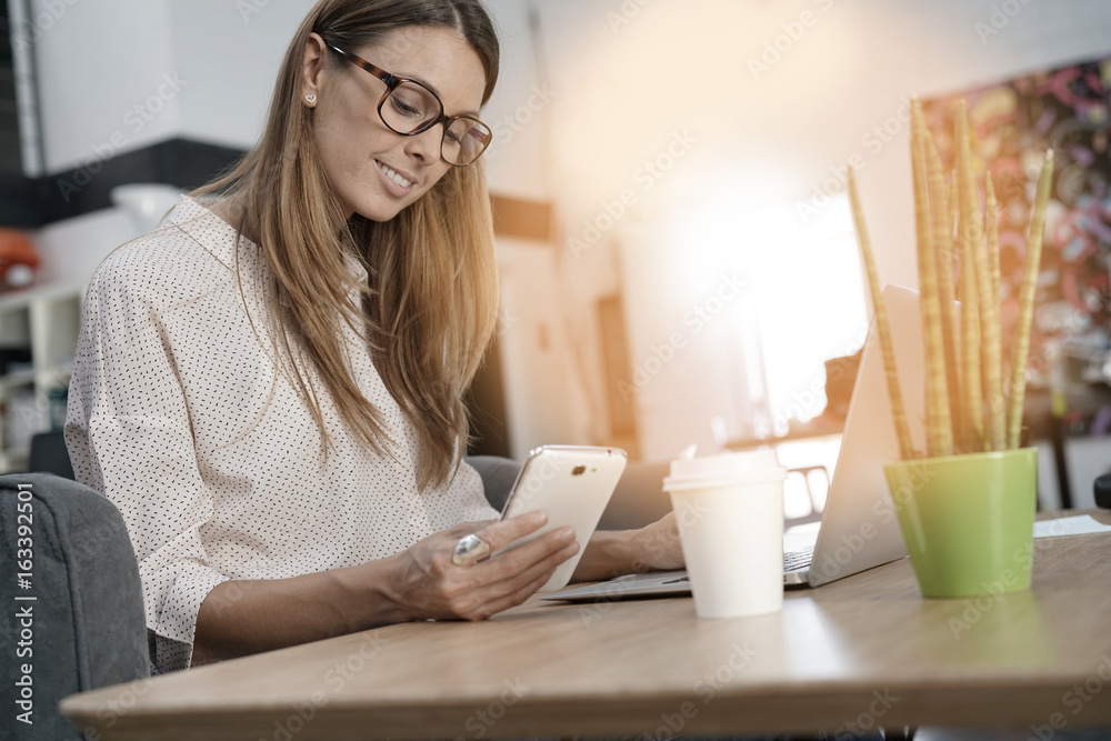 Young woman working on laptop computer in co-working place Young woman working on laptop computer in co-working place