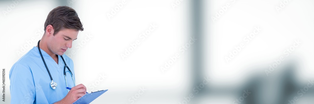 Doctor looking at clipboard against blurry grey office Doctor looking at clipboard against blurry grey office