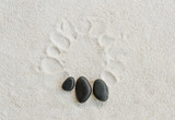 black stones on white sand background