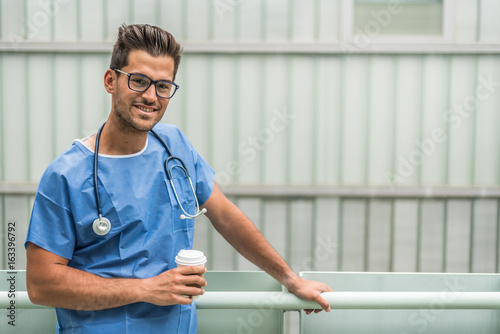 Cheerful medic drinking coffee