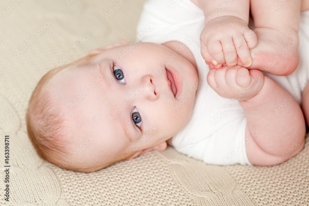 Cute beautiful baby with big eyes lies on the bed Cute beautiful baby with big eyes lies on the bed