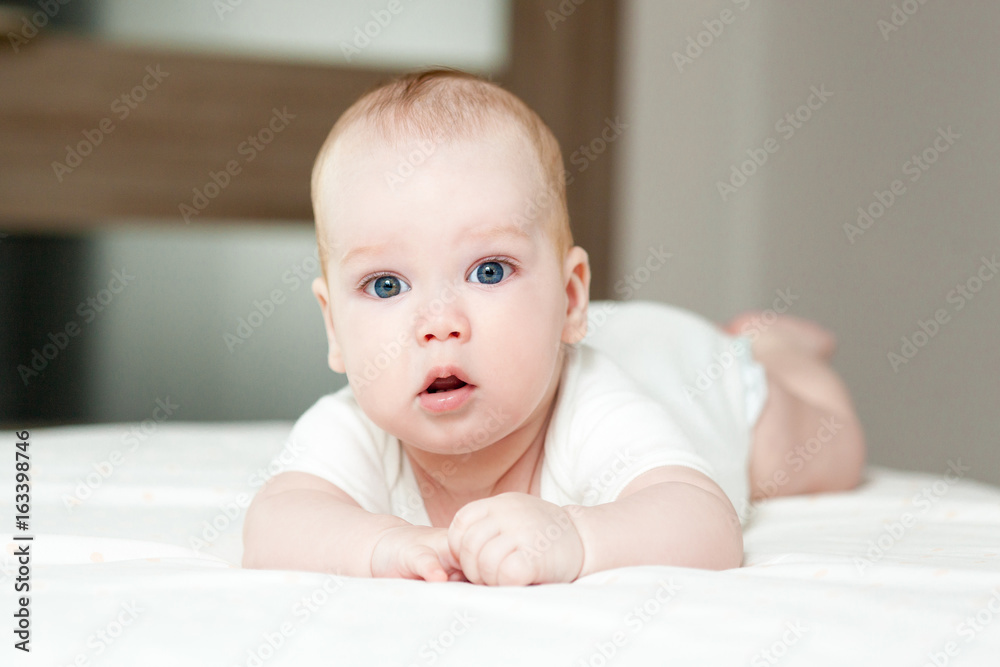 Cute beautiful baby with big eyes lies on the bed Cute beautiful baby with big eyes lies on the bed