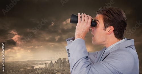 Businessman with binoculars in dramatic city