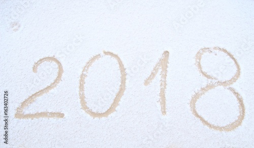 Happy New Year, 2018. New Year inscription on the snow. Winter day. Handwritten 