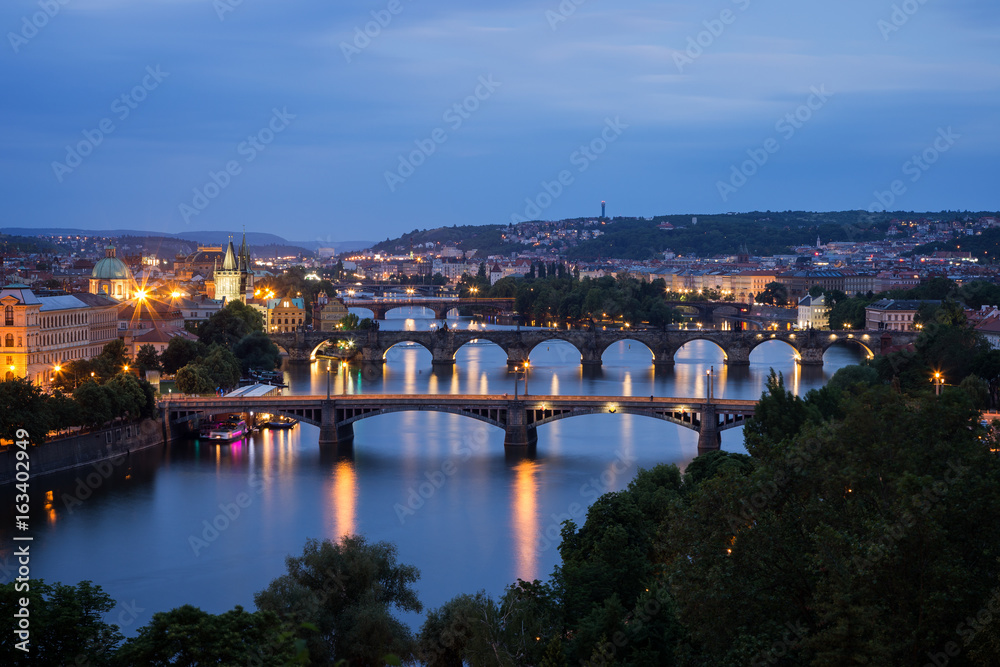 Lit buildings and bridges over Vltava River in Prague, Czech Republic, viewed slightly from above at dusk. Lit buildings and bridges over Vltava River in Prague, Czech Republic, viewed slightly from above at dusk.
