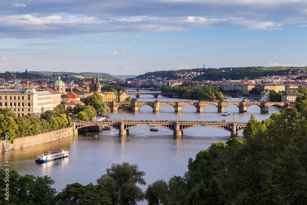 Buildings and bridges over Vltava River in Prague, Czech Republic, viewed slightly from above in the daytime.