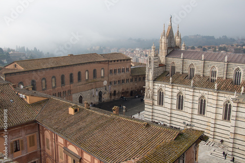Santa Maria della Scala and Metropolitan Cathedral of Santa Maria Assunta on Piazza del Duomo di Siena. View from facciatone Tuscany. Italy.