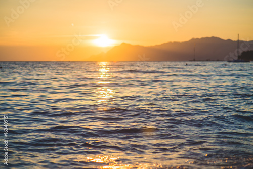 Sea waves and ripples at sunset background