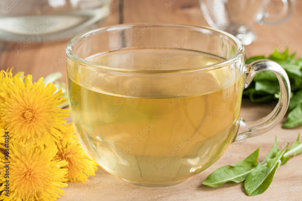 Dandelion tea in a cup, with dandelion leaves and flowers Dandelion tea in a cup, with dandelion leaves and flowers