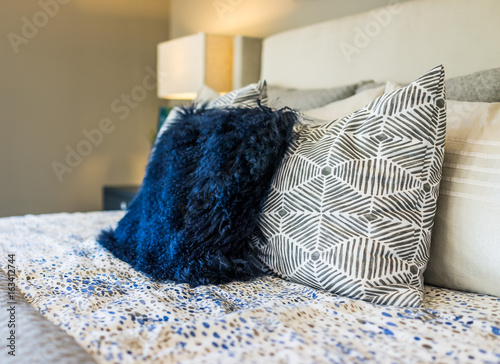 Foto Closeup of new bed comforter with decorative pillows in bedroom